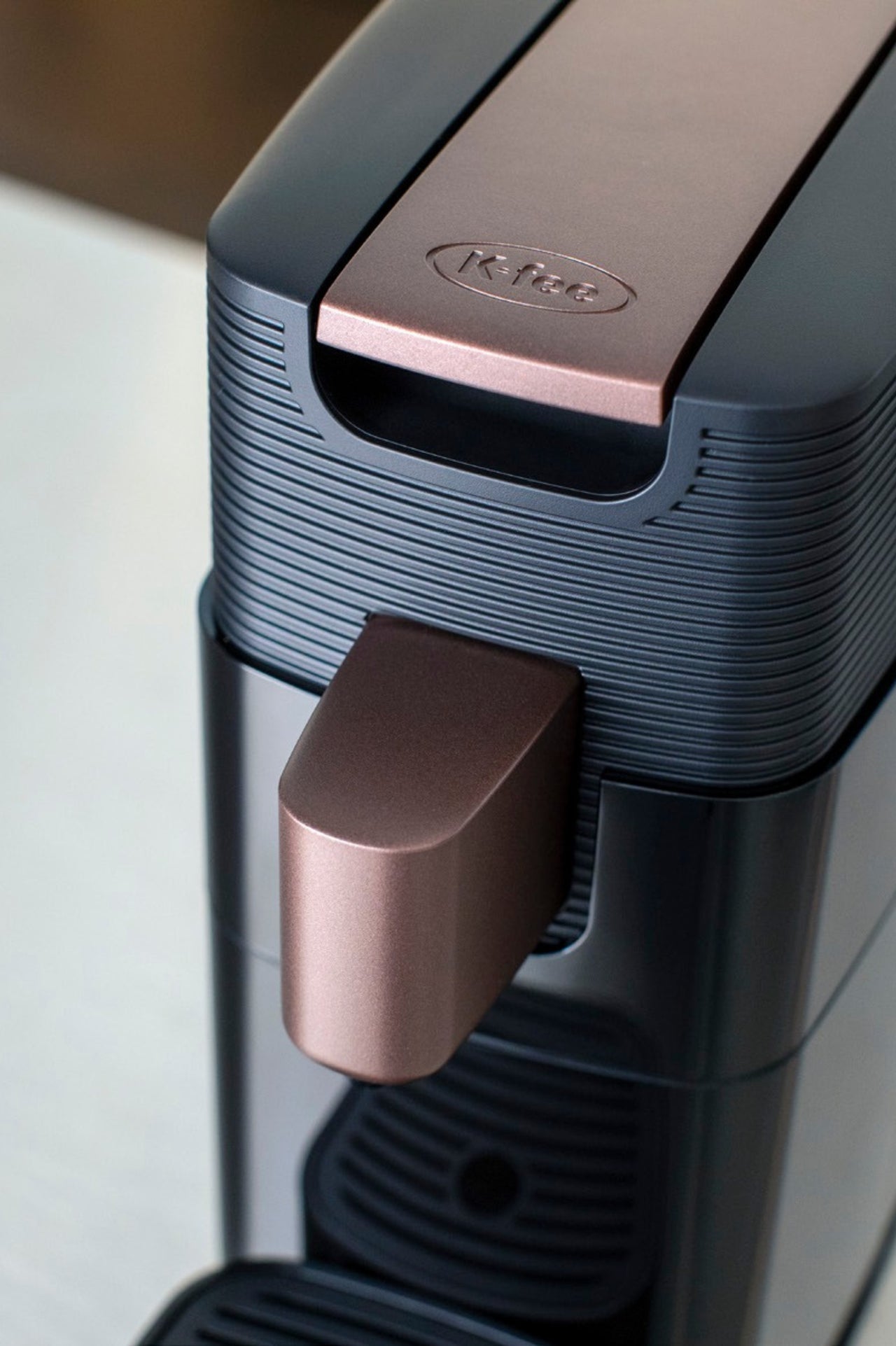 Coffee capsule being inserted into a compact automatic capsule coffee machine.